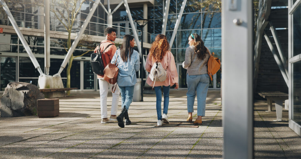 education campus, students and walking at college to class with talking, conversation or exam chat. back, friends and diversity outdoor at university with backpack for learning, scholarship and study